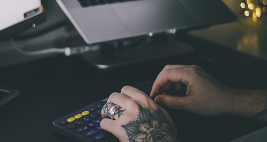 Two hands type on a keyboard; they belong to a nondeveloper working on a low-code automation project.